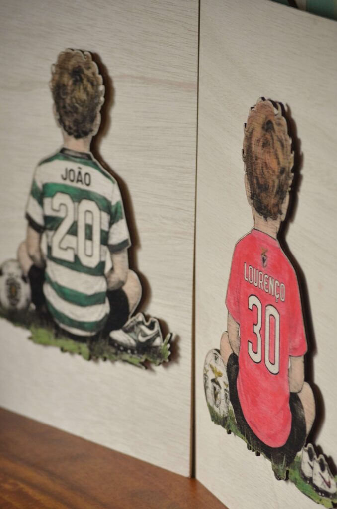 Quadro personalizado em madeira da Pinóquio Woodart, representando um menino com camisola do Benfica, e outro do sporting